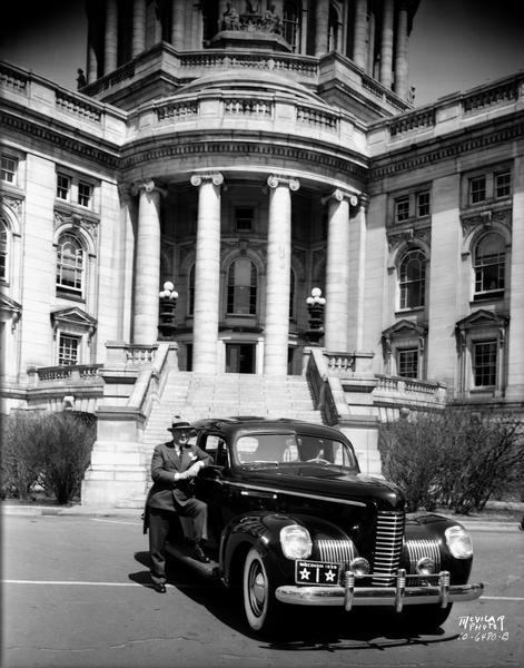 Governor Julius P. Heil in front of the Wisconsin State Capitol, standing next to his official car, a Nash manufactured in Kenosha, Wisconsin. Governor Heil was himself a leader in the Wisconsin automobile industry as the founder and head of the Heil Co., a leading manufacturer of truck bodies and refuse vehicles.