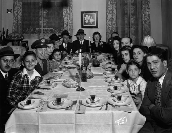 Close-up group portrait of Abe and Sarah Mintz's family gathered around the dining room table for Passover supper, 336 West Wilson Street.