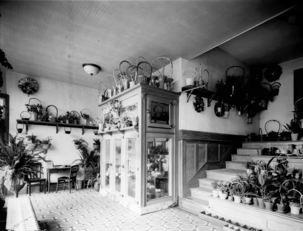 Interior view of University Floral Company, 747 University Avenue, displaying flowers, potted plants, baskets, and wreaths.
