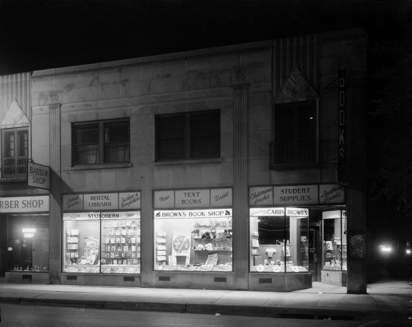 Night view of Brown's Book Shop, 673 State Street, with display windows.