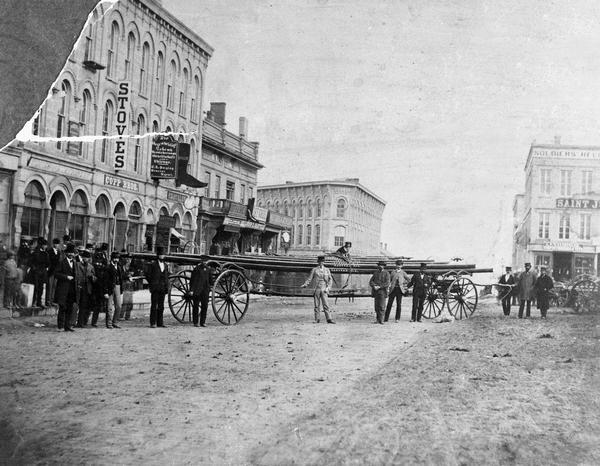 The first ladder wagon of Capitol Hook and Ladder Company #1 posed at the corner of Pinckney and Main streets to show off the length of the wagon and the 48-foot ladders. Four men were required to push this wagon to a fire. Capitol Hook & Ladder was a volunteer company formed in 1857. Until 1885, it was independent, and it purchased its own equipment.