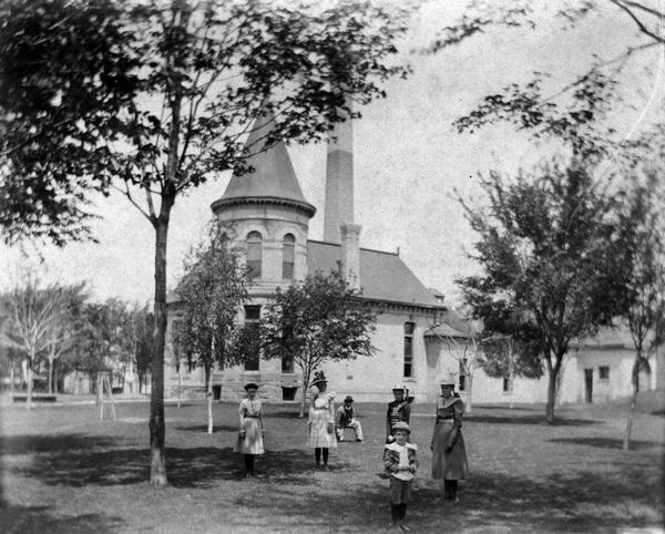 The Madison City Water Works pumping station at the intersection of Gorham and Livingston which provided pressure to the city's mains. A group of people stand on the lawn in the foreground.