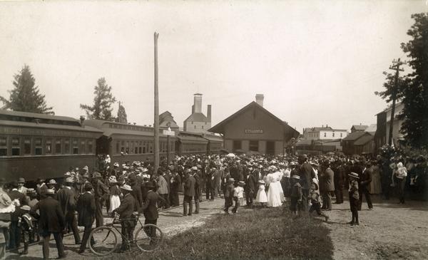 A large crowd at the Milwaukee Road depot, perhaps to greet William Jennings Bryan on the incoming train. The malthouse can be seen in the distance.