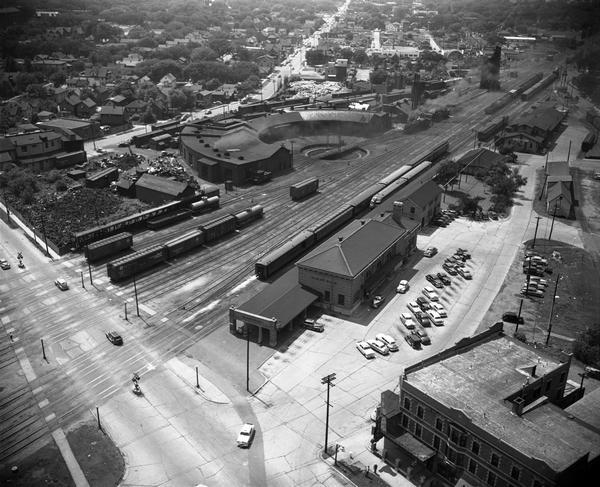 Aerial view of the Chicago, Milwaukee, and St. Paul Railroad station, roundhouse, and yard at the intersection of West Washington Avenue (across lower left corner) and Regent Street (angled mid-left to top).