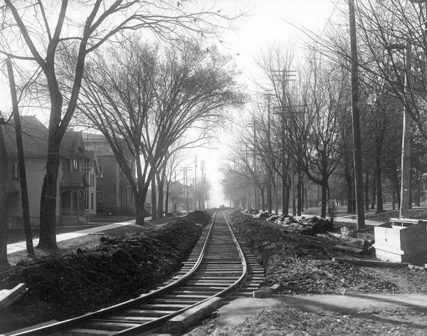 Newly-constructed streetcar tracks on Park Street, looking south from State Street. The eastern edge of the University of Wisconsin-Madison campus can be seen to the right of the tracks.