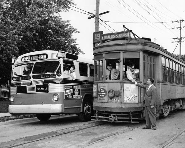 A posed photograph taken for the Milwaukee & Suburban Transport Corp. to mark the substitution of buses for streetcars on the West Burnham Street line.