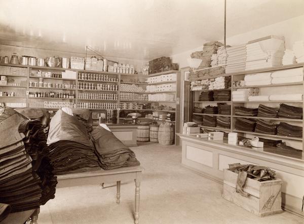 Supply room of the Northern Hospital for the Insane. Canned and bottled goods, kitchenware, clothing, and blankets are on the shelves.