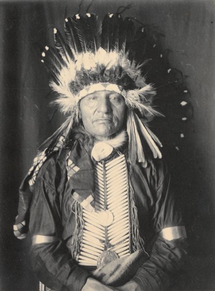 Portrait (Front) of Maga Ska (White Swan), Called Joseph H. Ellis, Jr?, in partial native dress with two peace medals, headdress and breastplate. Part of Siouan (Sioux) and Yankton Tribes.
