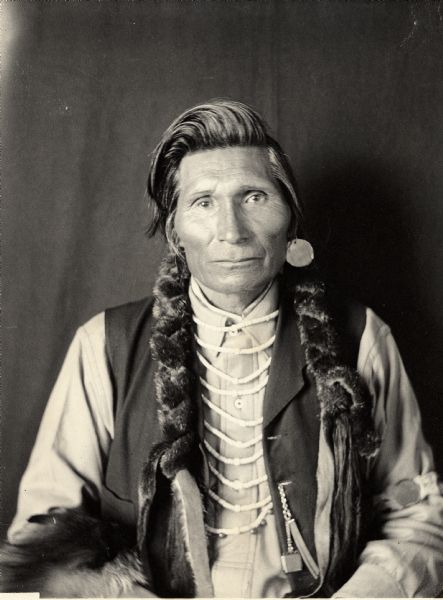 Studio portrait of Yumapeima (Grizzly Bear in the Center) in partial native dress with ornaments. Part of Shahaptian and Umatilla Tribes.
