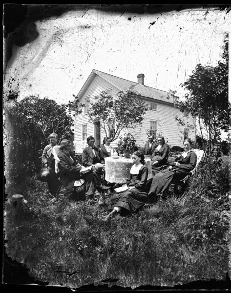 The Andrew Amundsen family is sitting around a table covered in a white knit cloth. Some of them are holding books. Their frame house is in the background. In 1870, according to the census, the Amundsen family consisted of Andrew, 52; Sarah, 45; Gjertrud; 18; Lausa, 15; Helena, 12; Louis, 9; and Susania, 7. Andreas Larsen Dahl married Gjertrud in August 1878.
