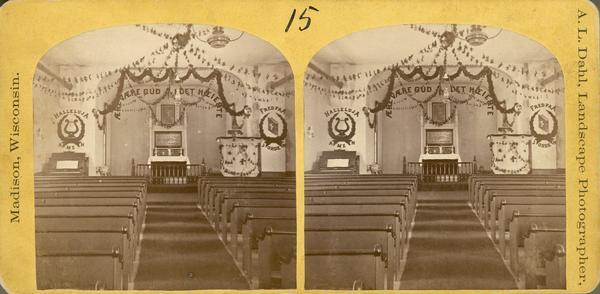 The interior of a Norwegian-American Lutheran Church decorated with garlands and religious admonitions in Norwegian.