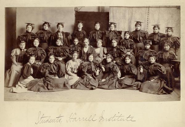 Harrell International Institute female students, posed in caps and gowns.