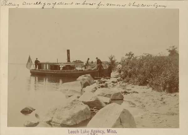 A Leech Lake Agency small pox patient is being put on a boat for removal to a hospital.