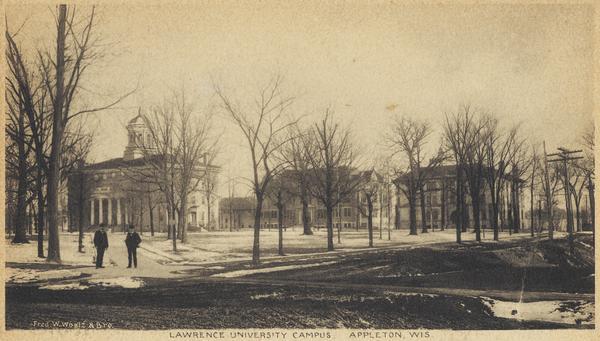 View across street toward campus. Two men are standing on the sidewalk on the left. Caption reads: "Lawrence College Campus, Appleton, Wis."