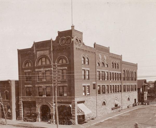 Elevated view of the Masonic Temple with bicycles in front of the entrance. It was built in 1895 of brick and brownstone in the Richardson Romanesque style. The first floor included retail space. It is listed in the State and National Register of Historic Places.