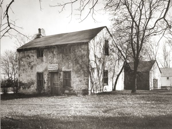 View of the Jeremiah Curtin house located at 8685 West Grange Avenue. This stone and stucco residence was erected in 1835.  It has been recognized as the boyhood home of linguist and mythologist Jeremiah Curtin. A sign above the doorway reads: "Birthplace of Jeremiah Curtin".