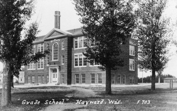 Front view of a public grade school. Caption reads: "'Grade School' Hayward, Wis."