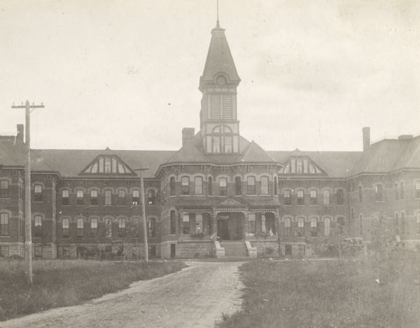 View of the Marathon County Asylum, with a dirt road leading to the main entrance.