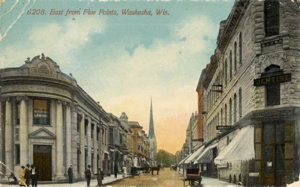 View looking east from Five Points, with a bank and dentist's office in the foreground. Caption reads: "East from Five Points, Waukesha, Wis."