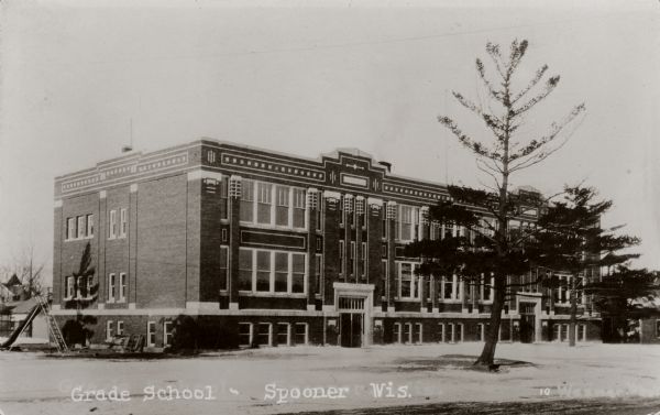 Exterior view of a grade school. Caption reads: "Grade School — Spooner Wis."