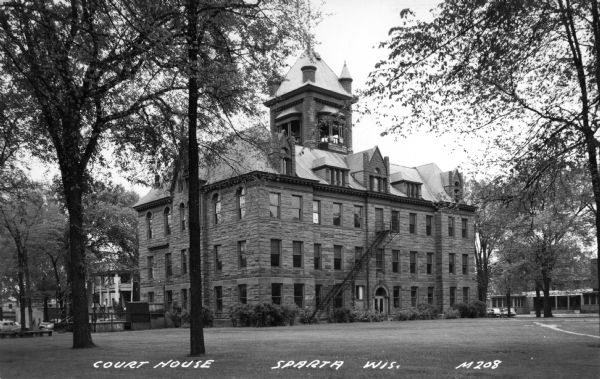 View across lawn with trees toward the courthouse. Caption reads: "Court House, Sparta, Wis."