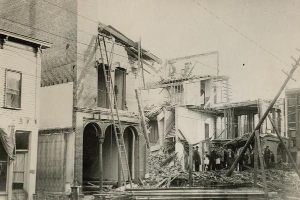 Demolished building with a group of men standing on the rubble.