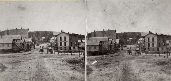 Stereograph of the unpaved main street in downtown Lodi, Wisconsin.