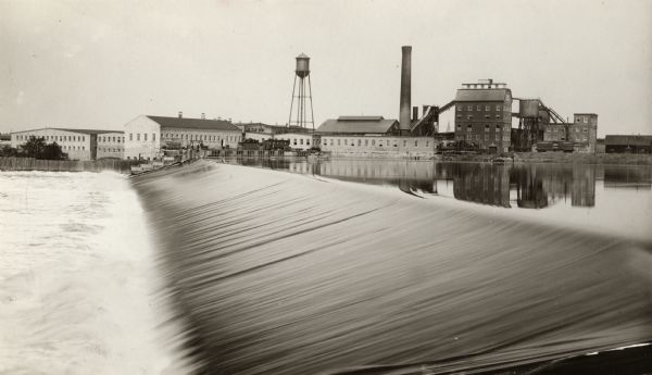 Nekoosa-Edwards Paper Company, Nekoosa Mill. Operated by water power to produce news and book paper from both ground wood and sulphite pulp on two wide paper machines. The frame structures at the right of the brick are the sulphite plants. The late Senator William F. Vilas was part owner of this plant.