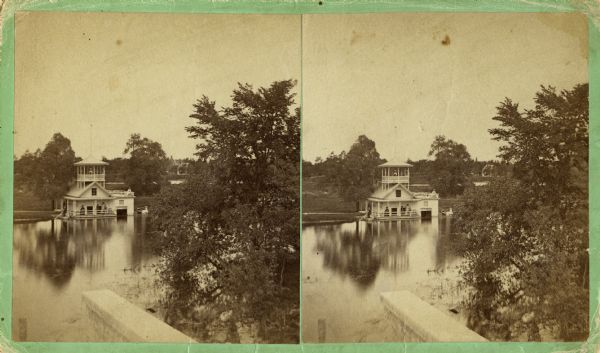 Stereograph of the Townsend House boathouse across a lake.