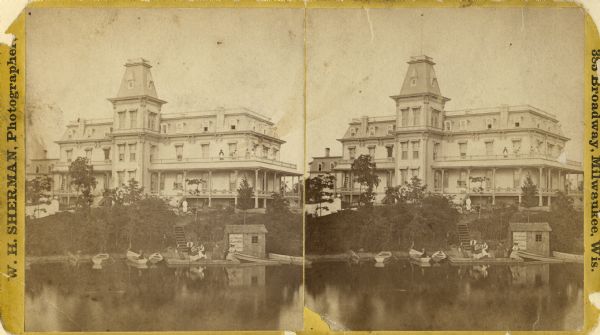Stereograph of Townsend House. Image includes people sitting on porch, grounds, boat dock.