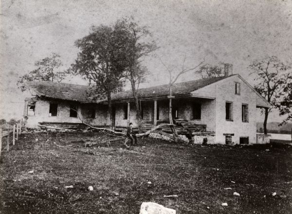 Fort Crawford Hospital. A man is sitting on a branch in the yard.