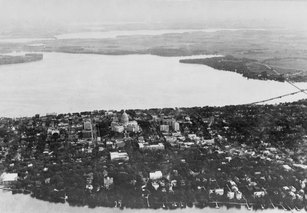 Aerial view of Madison looking southeast over the isthmus, showing the Four Lakes Country. Visible at the bottom is the Lake Mendota shoreline. At center, Lake Monona, just above, Lake Waubesa, and in the distance at the top, Lake Kegonsa.