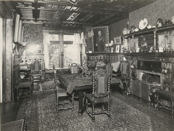 The ornate interior of the Lucius Fairchild house at 302 South Wisconsin Avenue (renamed Monona Avenue in 1877). Built by Lucius' father Jairus Fairchild in 1850, the house was redecorated with furniture from Paris purchased during Lucius' decade abroad in the 1870s. During the Fairchild's residence their home was considered the epitome of fashion and taste. It is said to have been paneled in red birch and cedar from Wisconsin. We know the picture was taken after 1880 because of the portrait of Fairchild in the corner which was painted by John Singer Sargent in that year. The portrait is now part of the Historical Society's museum collection; see Image #1884 or Museum #1942.305