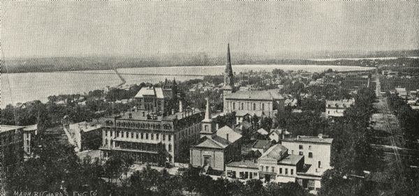 The First Baptist Church, pictured in the lower center area of the photograph, organized in 1847 and erected in 1854. St. Raphael's Cathedral in the background was erected around 1860.