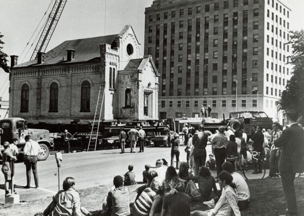 The moving of the Gates of Heaven Synagogue from West Washington Avenue to James Madison Park. Crowds line the streets, and a crane is in the background.