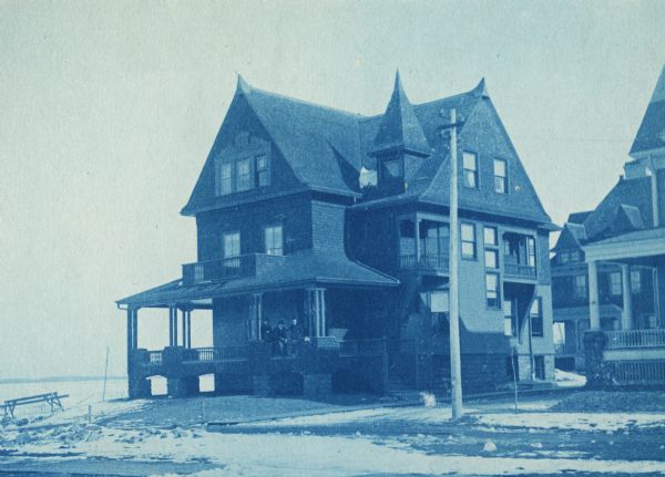 627 North Lake Street.  A cyanotype view looking northeast at the intersection of Lake Street and Mendota Court.  This house was built in 1892 for the Chi Psi fraternity, previously located at 602 North Frances Street.  Chi Psi remained here until 1909.  From 1913 until its demolition in 1924-1925, the house was occupied by the Sigma Alpha Epsilon fraternity.  The site was earlier used in 1853 by Daniel Gorham as the location for his steam sawmill.  It was replatted for residential use in 1890.  Visible at right is the Delta Tau Delta chapter house, 621 North Lake Street.  Visible in right foreground is another fraternity house located at 616 Mendota Court.