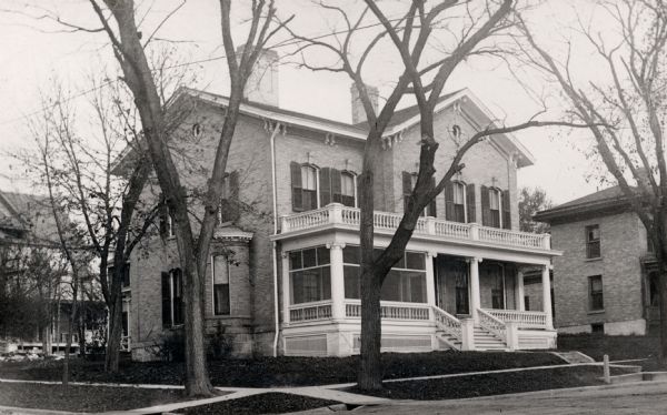 Dr. and Mrs. Philip R. and Katherine B. Fox residence at 28 West Wilson Street, corner of South Carroll Street. The house was constructed of Milwaukee brick and was completed by Peter Young in 1871. He lived there until it was sold to the Foxes in 1903. The residence became a boarding house between 1935 and 1954 when it was demolished.