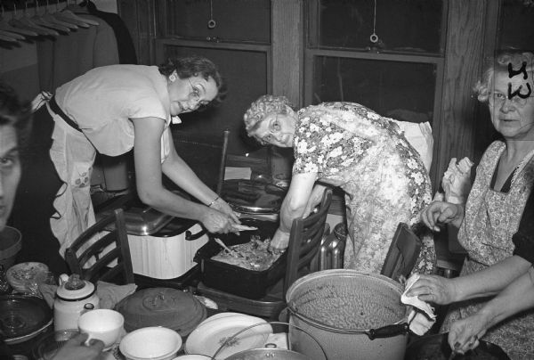 Members prepare a banquet to celebrate the eleventh anniversary of Auxiliary No. 2, United Automobile Workers (Seaman Body Company), October 23, 1946.

Executive board member Laura Miller in flowered dress.
