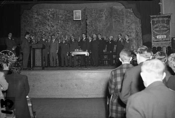 Installation of officers, Local 1131, United Electrical Workers (The Louis Allis Company),  South Side Armory Hall.  
Left to right: Phil Smith, field organizer; Clifford Jones, guide; Lawrence Staub, recording-secretary; John Brandt, John Behma, executive board members; Alois R. Michalski, financial secretary and treasurer; Victor Ziegler, president; Harry Nichols, vice-president; Werner Milz, trustee; Vincent Narloch, sargeant-at-arms; Albert Pautz, Thomas White, Harry Phillips, Dominic Balestreri, bargaining committee members.