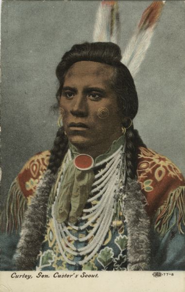 Native American in native dress, two braids wrapped in fur, multi-strand beaded necklace. Caption reads: "Curley, Gen. Custer's Scout."