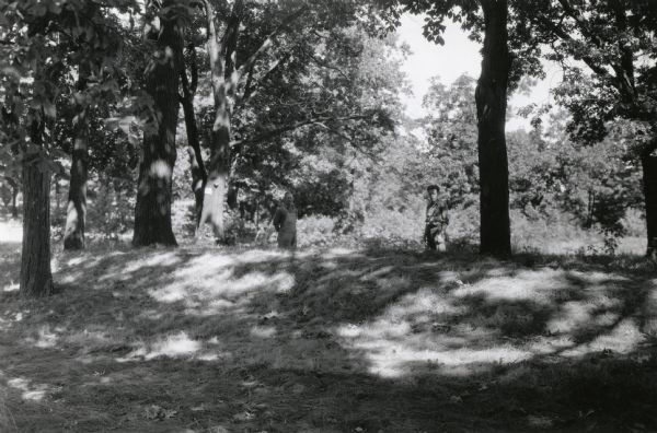 Burl Briggs (right), and an unknown companion pose behind a linear burial mound on the University of Wisconsin-Madison campus.