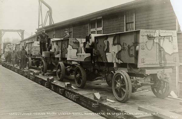 Camoflagued trucks being loaded on a train for shipment.  The trucks, a product of the Four Wheel Drive Company of Clintonville, were manufactured at the Kissel Car Company plant in Hartford during World War I. Over 20,000 Four Wheel Drive trucks were manufactured for the American and British armies.