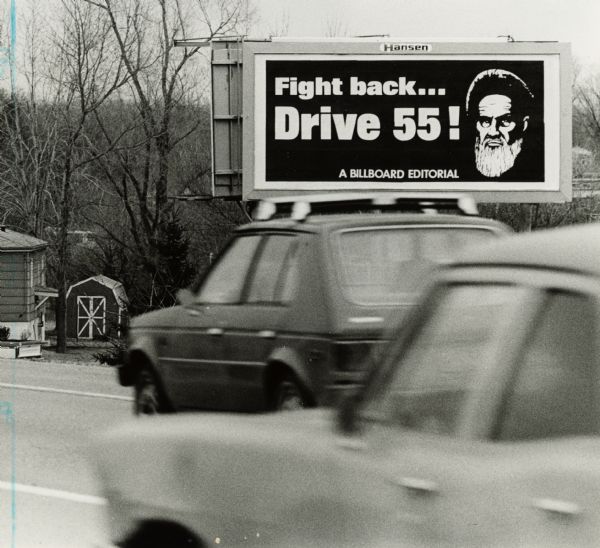 Billboard urging Wisconsin motorists to obey the 55 miles per hour speed limit that is illustrated with a portrait of Ayatollah Khomeini, the spiritual leader of Iran's Islamic Revolution.  The linkage of the speed limit with the Iranian leader graphically illustrates the degree to which the national speed limit was enacted as a security measure not as an energy saving device.