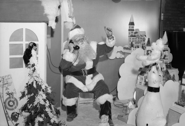Santa Claus talks on a telephone seated in a Christmas display in Manchester's Department Store.