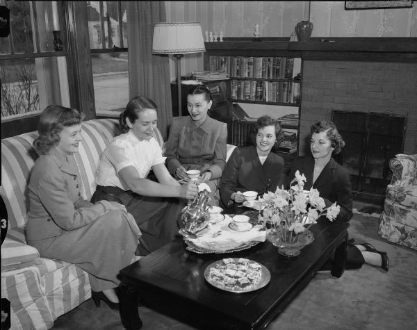 Louise Shoup, wife of Henry W. Shoup, commanding officer of Truax Field, gives a coffee party to introduce the new wives to some of the current wives, left to right: Mrs. Robert C. Burgess, Mrs. Shoup, Agnes, wife of James M. Hernly, Mrs. Leo M. Wright, and Mrs. Doyle Black.