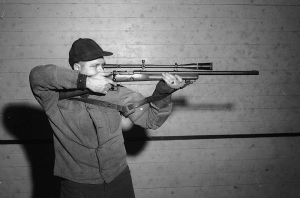 Paul Haberman, member of the Madison Legion Rifle and Pistol Club, aiming a rifle. The Club is sponsoring the "Little Worlds Rifle and Pistol Championship Match," April 20-27, 1941.