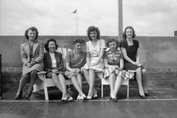 Preparing for War Bond Drive at Breese Stevens Field are Manchester's, Inc., employees Charmain Sabanske, Jenny McMahon, Helen Heisman, Jean Stehr, Jeanne Fleury and Jenny Cripps. Harry S. Manchester, Incorporated, is an issuing agent for war bonds and stamps.
