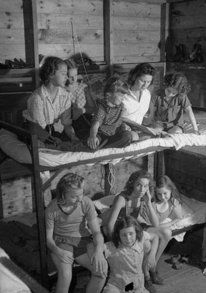 Young girls posing on the top and bottom bunks at YWCA's Camparia Olbrich on Lake Mendota.  In the upper bunk, left to right: Kathryn Eye, Barbara Fellows, Renee L'Hommedieu, Marion Marko, and Sedate Holland. In the lower bunk, left to right: Janet Petrie, Darlene Kohl, Marilyn Jones, and Peggy Kropf.