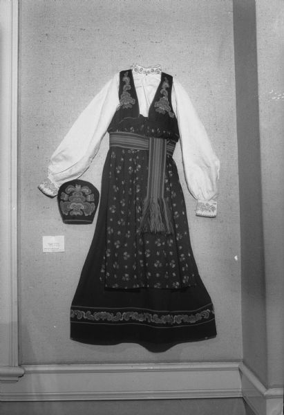 Norwegian dress and hat displayed as part of an exhibit of Elaine Smedal's "Norwegian Wisconsin as a Source of Design." Elaine Smedal arranged the exhibit as part of her Masters thesis. The collection was displayed at the Memorial Union.