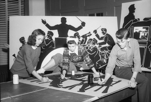 Madison Youth Center "The LOFT" Students painting a mural for the opening of "The LOFT," a high school activities center, at the YMCA. LOFT = Lots Of Fun Times. Left to right: Joan Wells, Ruth Hart, George Van Tassel.